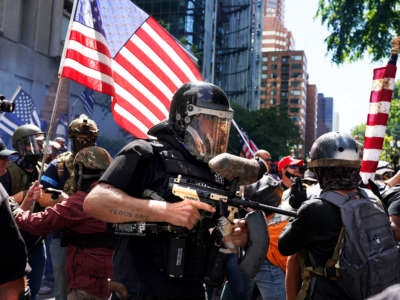 A member of the Proud Boys fires a paint ball gun into a crowd of anti-police protesters on August 22, 2020, in Portland, Oregon.