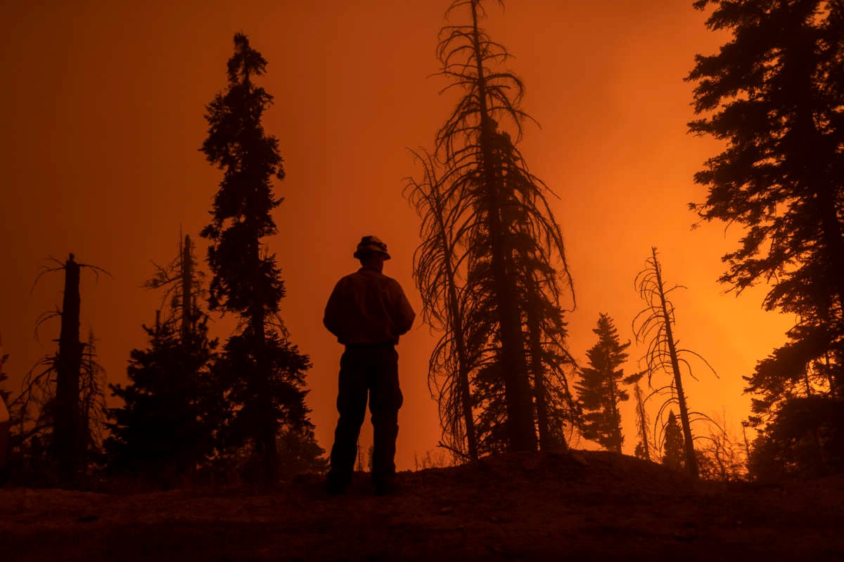 A firefighter watches california burn in the distance