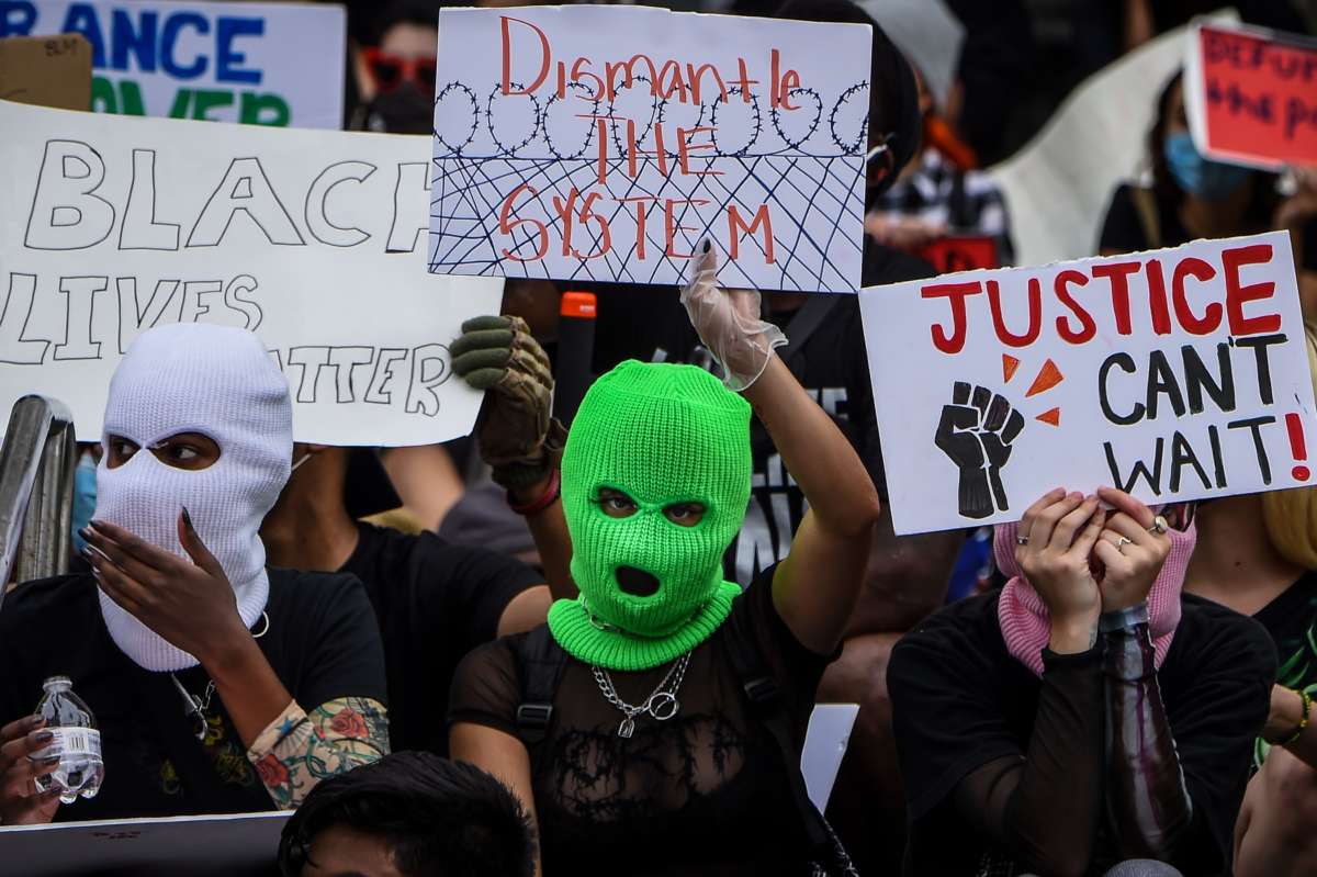 People with face coverings protest police brutality
