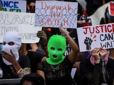 People with face coverings protest police brutality