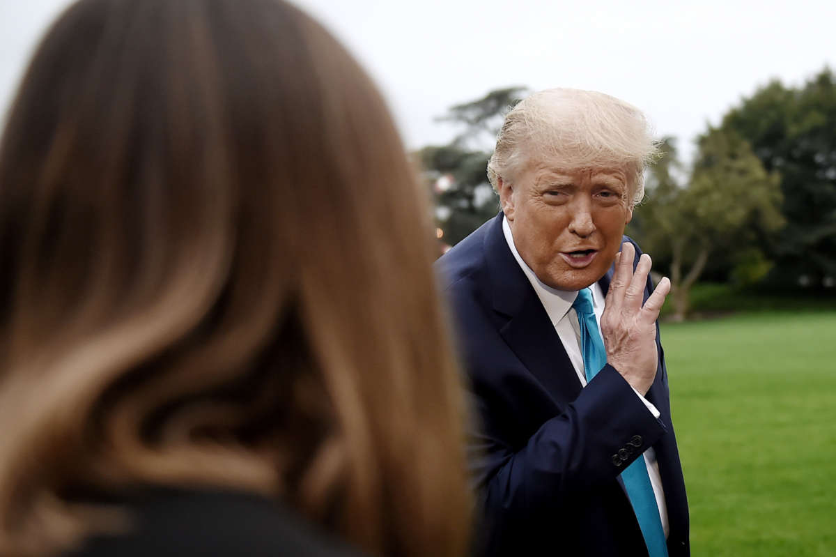 President Trump whispers to a White House staffer as he makes his way to board Marine One from the South Lawn of the White House in Washington, D.C. on September 26, 2020.