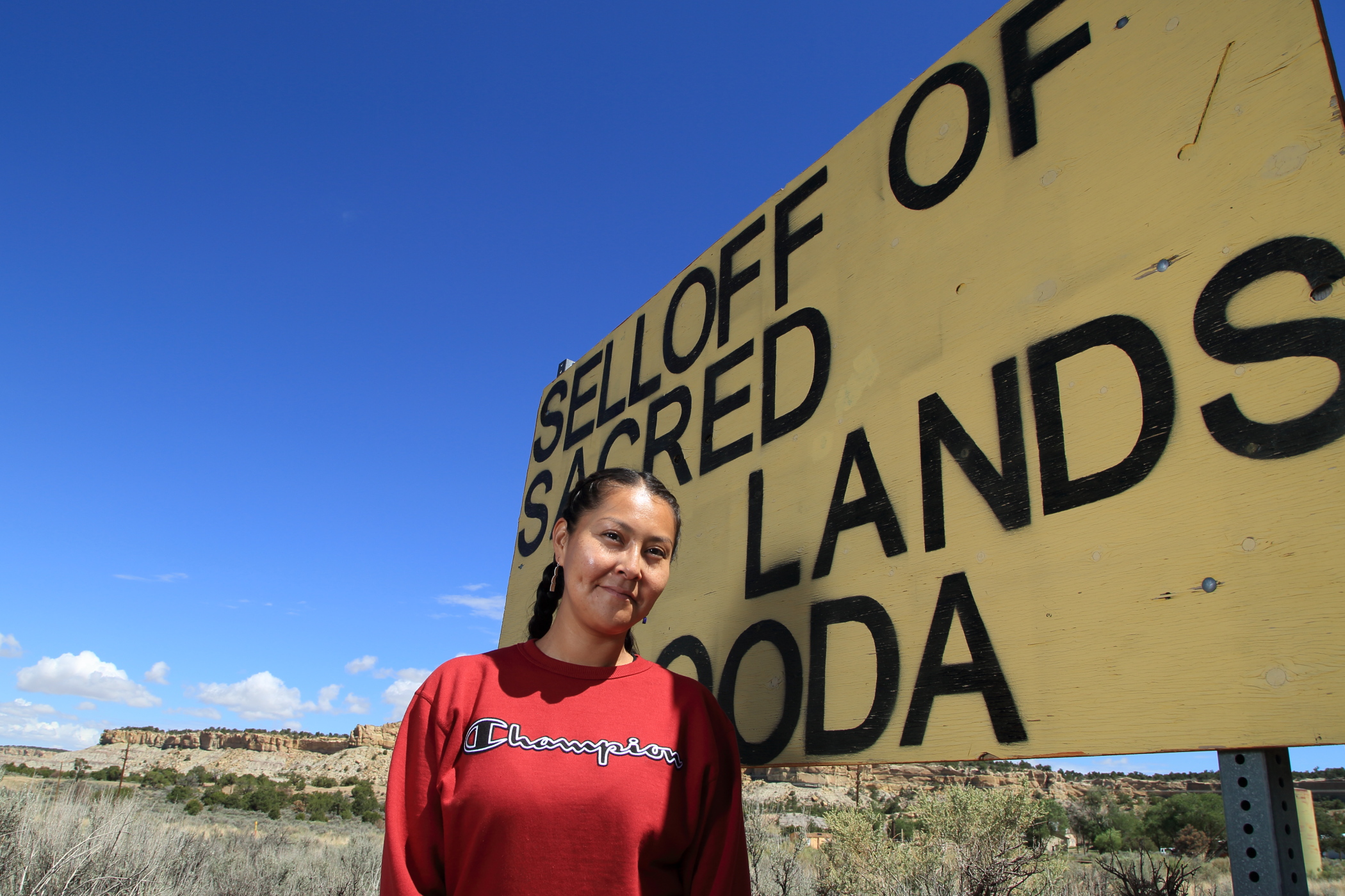 Kendra Pinto of Diné CARE stands beside one of several protest signs (“dooda” means “no” in Navajo) that she and colleagues erected along US Route 550 in Greater Chaco.