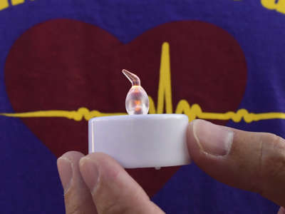 A person holds an electronic candle as health care workers and supporters hold a vigil in memory of healthcare workers who died of COVID-19 on September 1, 2020, in Alhambra, California, where attention was also called to an alleged lack of personal protective equipment at three local Alhambra hospitals.