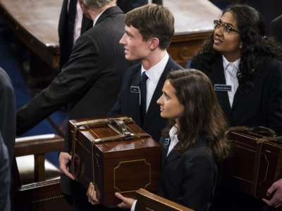 Congressional pages carry the chests containing the Electoral College votes from the states and territories for president of the United States during a joint session of Congress at the U.S. Capitol in Washington on January 6, 2017.