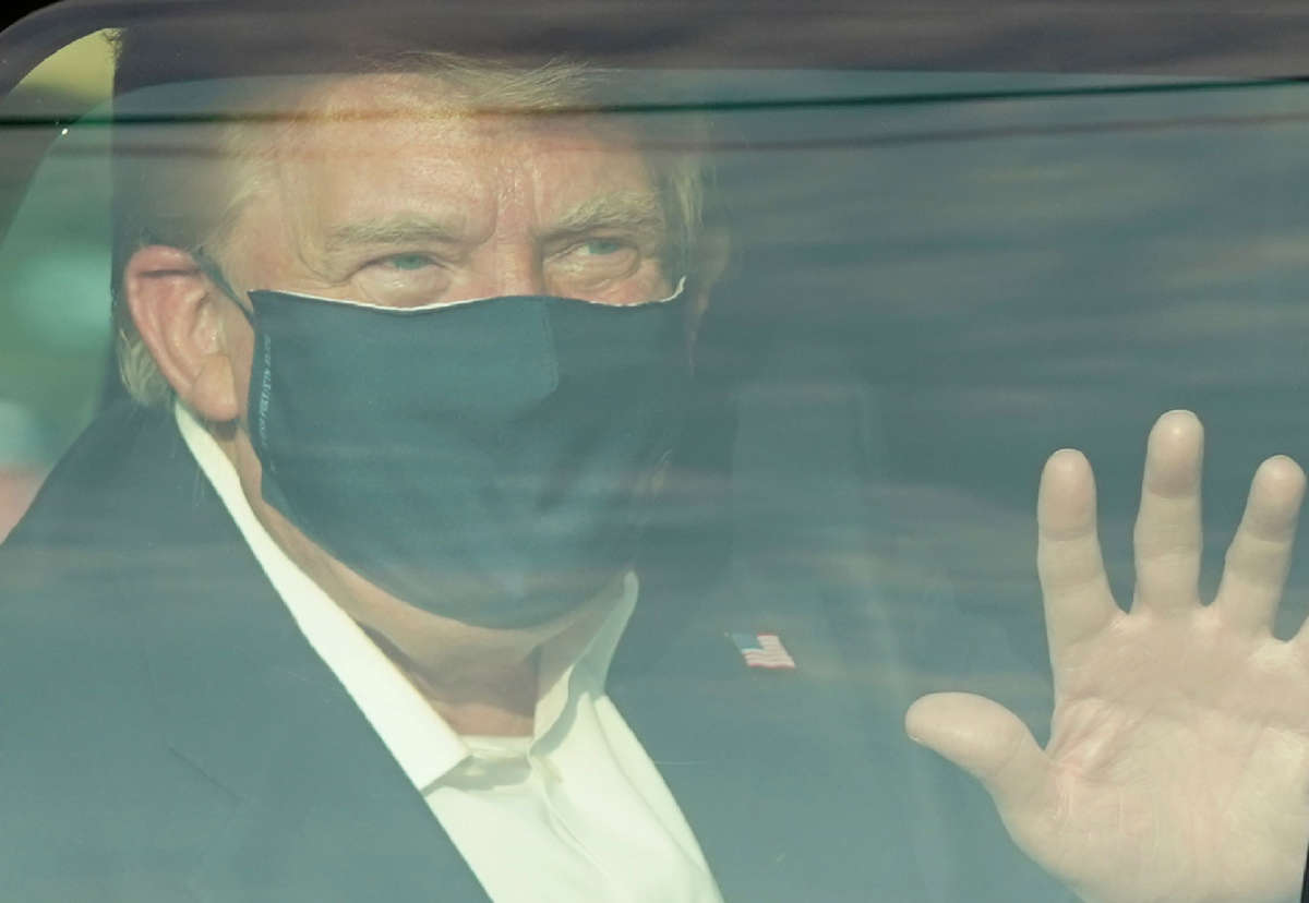 A car with President Trump drives past supporters in a motorcade outside of Walter Reed Medical Center in Bethesda, Maryland, on October 4, 2020.