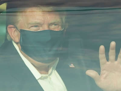 A car with President Trump drives past supporters in a motorcade outside of Walter Reed Medical Center in Bethesda, Maryland, on October 4, 2020.