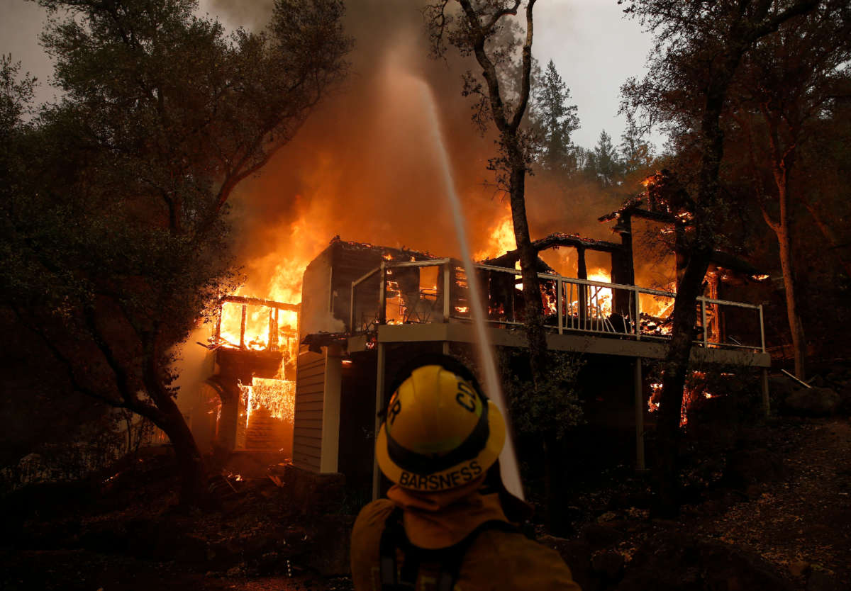 A Cathedral City firefighter puts water on a burning structure at the Meadowood Napa Valley resort in St. Helena, California, on September 28, 2020.