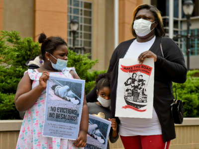 Migreldi Lara, a single mother of three who is out of work as a hair stylist due to the pandemic, stands with her daughters during a protest outside the Berks County Services Building in Reading, Pennsylvania, on September 1, 2020.