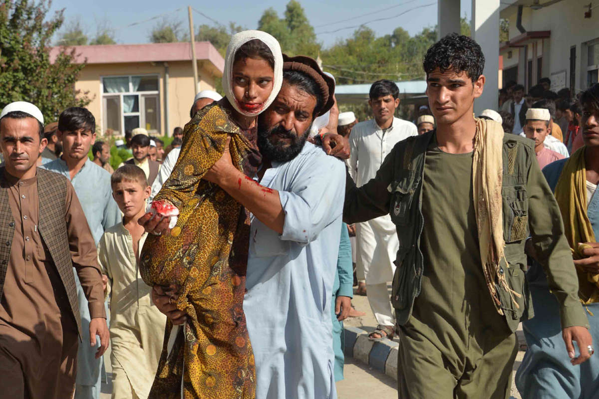 An injured youth is carried to a hospital following a car bomb attack that targeted a government building in eastern Afghanistan on October 3, 2020.