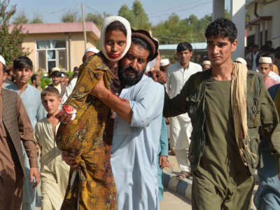 An injured youth is carried to a hospital following a car bomb attack that targeted a government building in eastern Afghanistan on October 3, 2020.