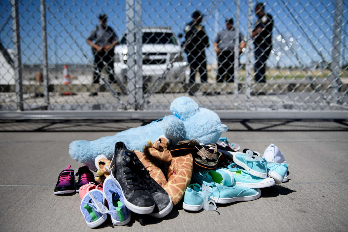 Security personal stand before shoes and toys left at the Tornillo Port of Entry where minors crossing the border without proper papers have been housed after being separated from adults, June 21, 2018, in Tornillo, Texas.