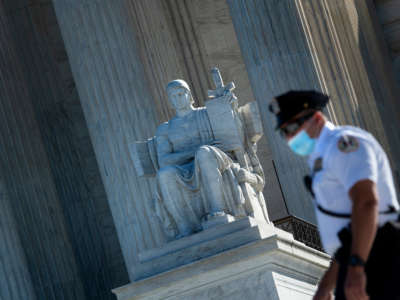 A guard is seen wearing a mask in front of the U.S. Supreme Court, on October 2, 2020, in Washington, D.C.
