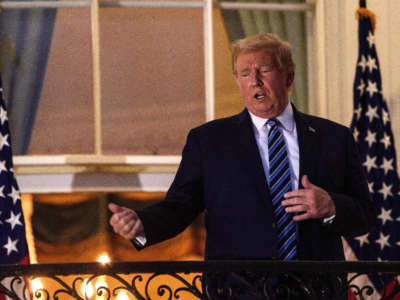 President Trump gestures from the Truman Balcony upon his return to the White House from Walter Reed Medical Center in Washington, D.C., on October 5, 2020.