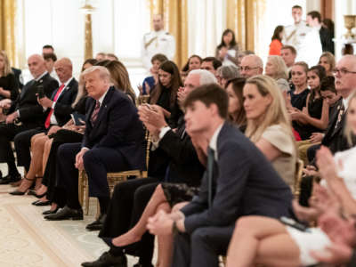 President Donald J. Trump listens as songs are sung at a remembrance candle lighting during a reception to honor Gold Star Families Sunday, September 27, 2020, in the East Room of the White House.
