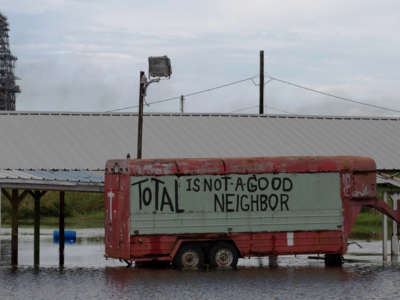 A protest sign is seen on a truck in flood water, from Hurricane Laura, by a Total oil refining plant near Port Arthur, Texas, on August 28, 2020.