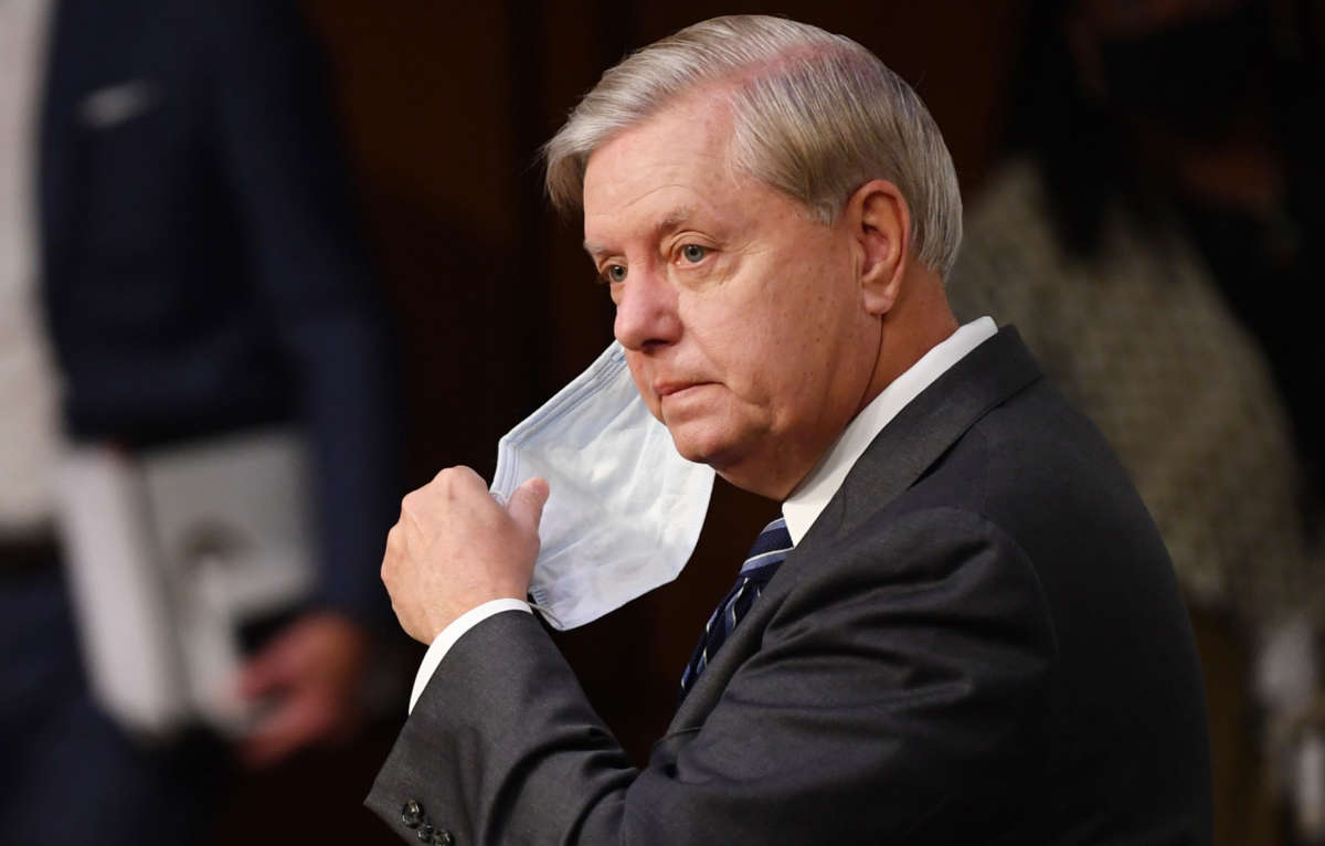 Chairman Sen. Lindsey Graham holds his face mask before nominee Judge Amy Coney Barrett's testimony on the third day of her confirmation hearing before the Senate Judiciary Committee on Capitol Hill on October 14, 2020, in Washington, D.C.