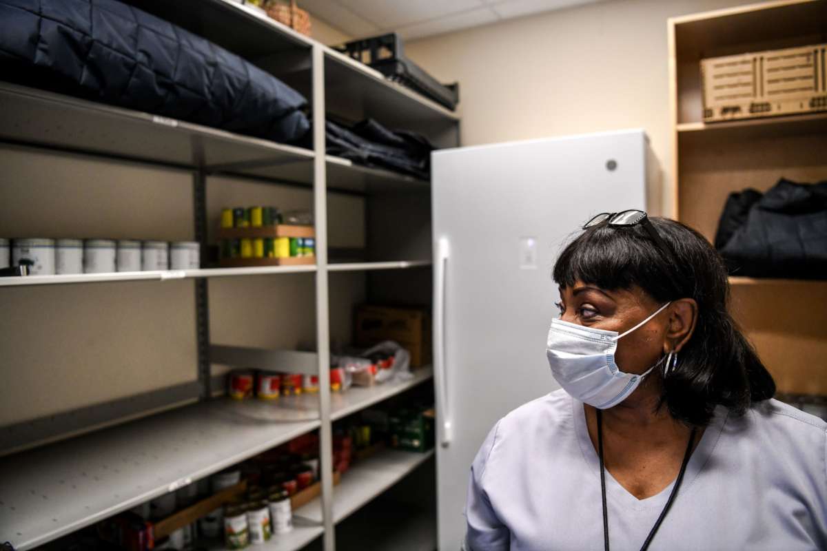 A medical worker looks at empty storage shelves in her hospital