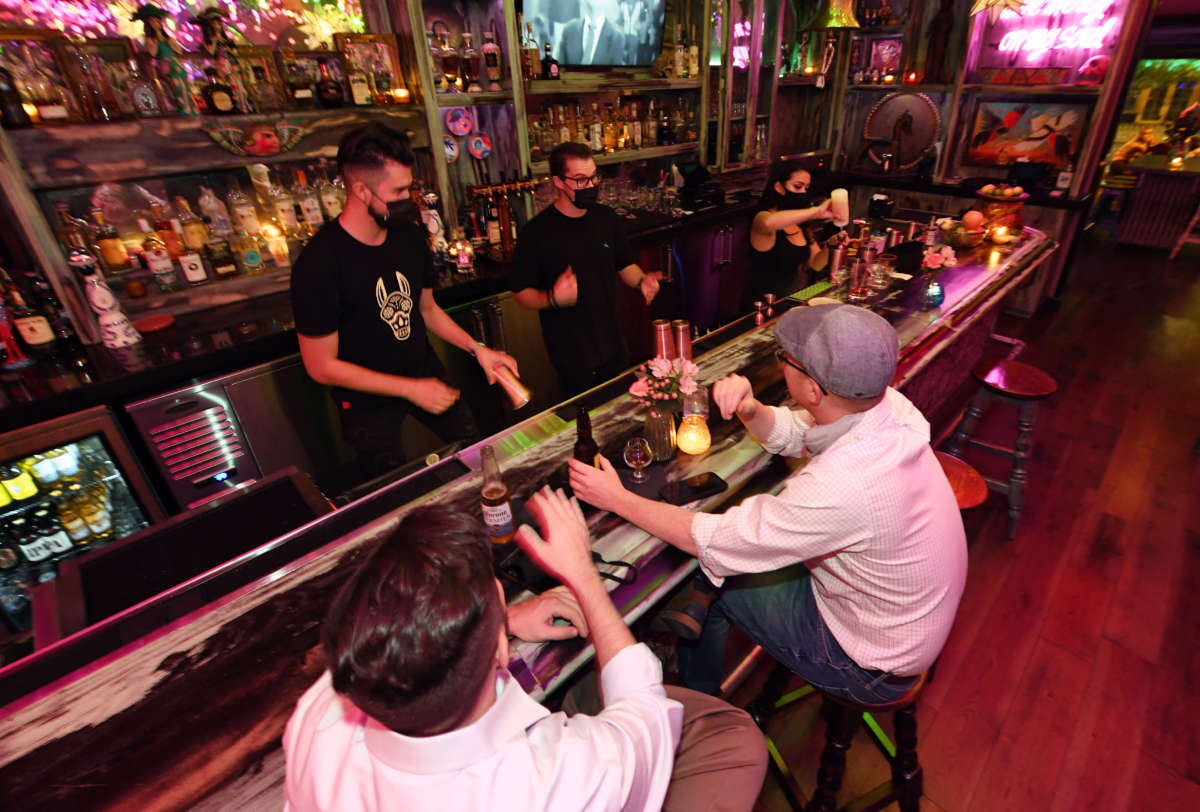 Bar workers serve patrons at the bartop after reopening at Lucky Day Bar in the Fremont East Entertainment District on September 21, 2020, in Las Vegas, Nevada.