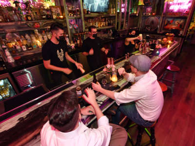 Bar workers serve patrons at the bartop after reopening at Lucky Day Bar in the Fremont East Entertainment District on September 21, 2020, in Las Vegas, Nevada.