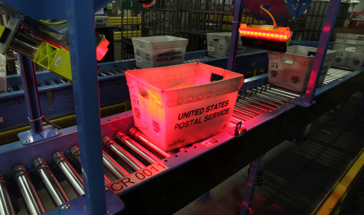 A tote of mail is scanned as it travels along a conveyor belt on December 18, 2014, at the USPS sorting facility in Scarborough, Maine.