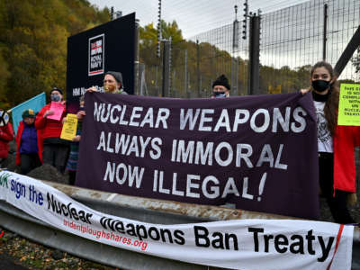 Anti-nuclear campaigners hold banners and placards outside Her Majesty's Naval Base, Clyde, on October 25, 2020, in Faslane, Scotland. Demonstrators were there to mark the announcement of an international treaty banning nuclear weapons which has been ratified by a 50th country, the UN has said.
