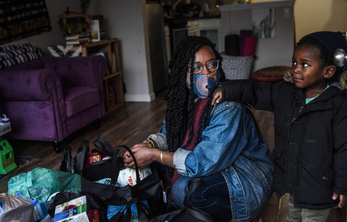 After checking the food and essential items that were delivered to her, Sevonna Brown of Black Women's Blueprint looks at her son on May 11, 2020, in the Bedford-Stuyvesant neighborhood in the Brooklyn borough in New York City.