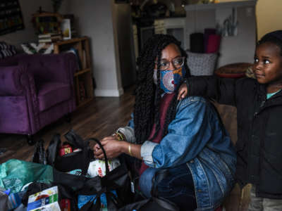 After checking the food and essential items that were delivered to her, Sevonna Brown of Black Women's Blueprint looks at her son on May 11, 2020, in the Bedford-Stuyvesant neighborhood in the Brooklyn borough in New York City.