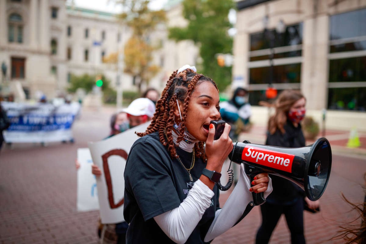 Taylor Hall leads a march from the statehouse to the city county building while using a megaphone during the rally of the "Crossroads of Democracy: Day of Action" outside the Indiana Statehouse on October 17, 2020.