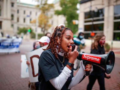 Taylor Hall leads a march from the statehouse to the city county building while using a megaphone during the rally of the "Crossroads of Democracy: Day of Action" outside the Indiana Statehouse on October 17, 2020.