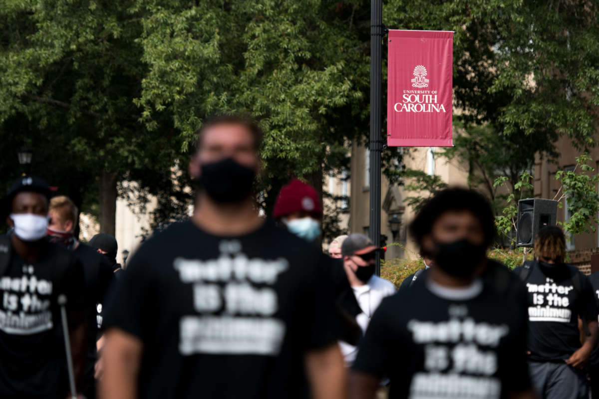 University of South Carolina football players walk to a team bus after participating in a demonstration on campus against racial inequality and police brutality on August 31, 2020, in Columbia, South Carolina.