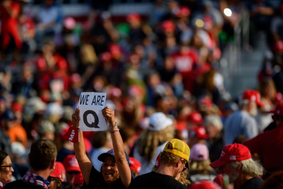 A woman holds up a QAnon sign to the media as attendees wait for President Donald Trump to speak at a campaign rally at Atlantic Aviation on September 22, 2020, in Moon Township, Pennsylvania.