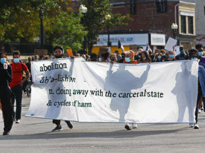 Protesters holding a banner with the definition of "abolition" move up Washington Street, from Nubian Square toward downtown Boston, Massachusetts, on September 25, 2020.