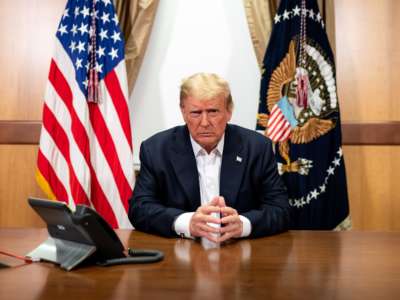 In this handout provided by The White House, President Donald Trump participates in a phone call with Vice President Mike Pence, Secretary of State Mike Pompeo, and Chairman of the Joint Chiefs of Staff Gen. Mark Milley in his conference room at Walter Reed National Military Medical Center on October 4, 2020, in Bethesda, Maryland.