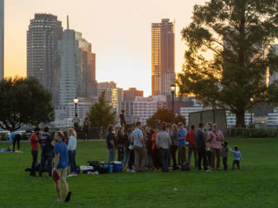 A group of people without masks avoid social distancing at Rockefeller Park during sunset as the city continues Phase 4 of re-opening following restrictions imposed to slow the spread of coronavirus on September 30, 2020, in New York City.