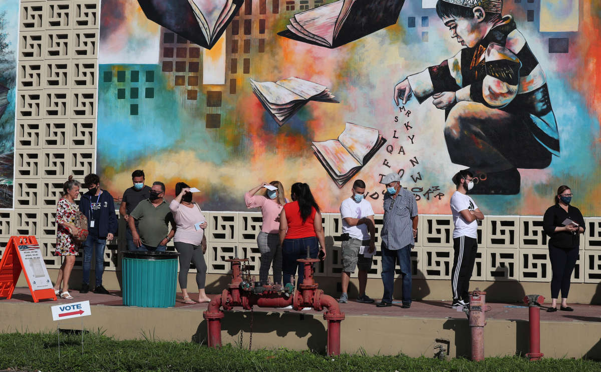 Voters wait in line to cast their early ballots at the Hialeah John F. Kennedy Library polling station on October 28, 2020, in Hialeah, Florida.