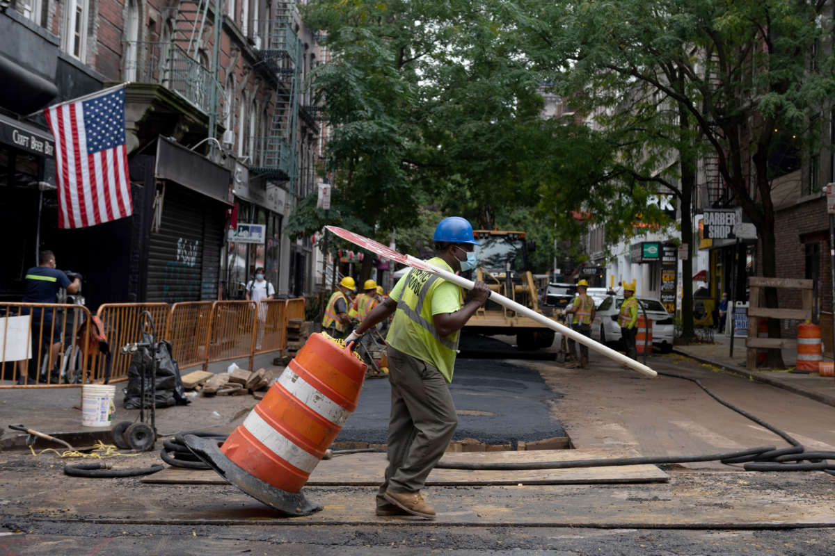 A construction worker wearing a mask drags a barricade on a closed street on September 29, 2020, in New York City.