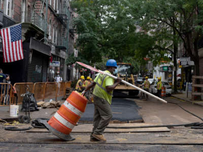 A construction worker wearing a mask drags a barricade on a closed street on September 29, 2020, in New York City.