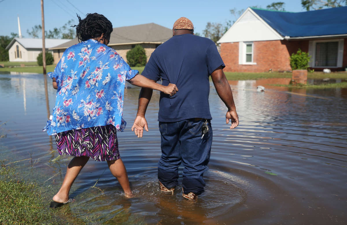 Patrick King and Soncia King walk through flood waters from Hurricane Delta toward their home, which they were still repairing from damage from Hurricane Laura, on October 10, 2020, in Lake Charles, Louisiana.