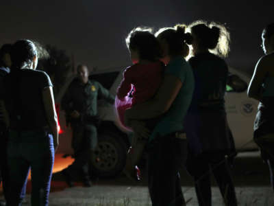 A Honduran mother holds her two-year-old as U.S. Border Patrol agents take them and other migrants into custody at the U.S.-Mexico border on June 12, 2018, in McAllen, Texas.