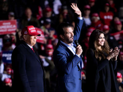 President Trump and Kimberly Guilfoyle listen while Donald Trump Jr. speaks during a rally at Kenosha Regional Airport, November 2, 2020, in Kenosha, Wisconsin.