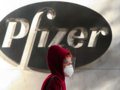 A woman wears a facemask as she walks by the Pfizer world headquarters in New York on November 9, 2020.