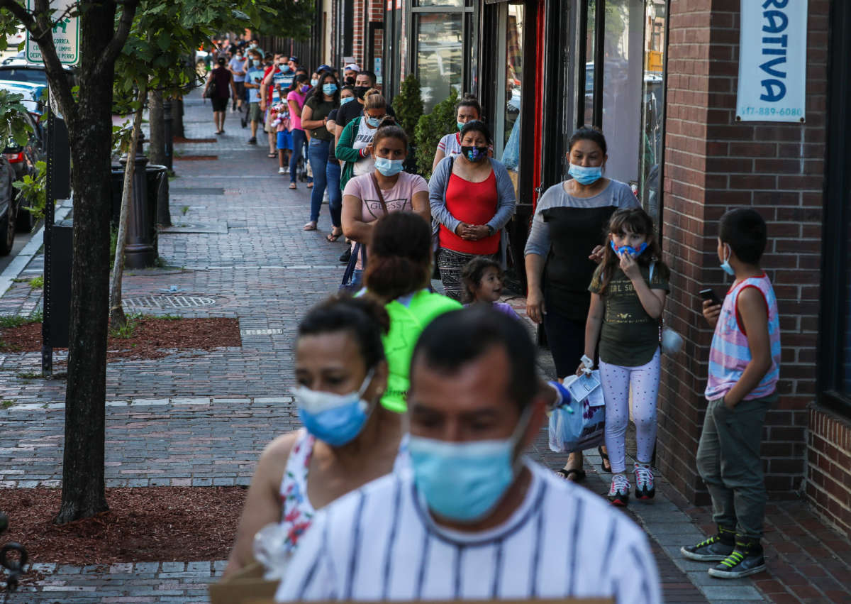 Hundreds of community members line up early to pick up food boxes at Chelsea Collaborative during their weekly food drive in Chelsea, Massachusetts, on July 15, 2020.