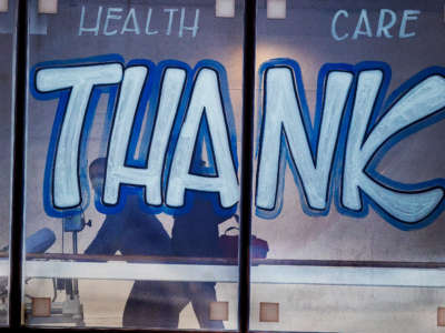Patients are transported past thank you signs in the windows at Boston Medical Center in Boston on October 20, 2020.