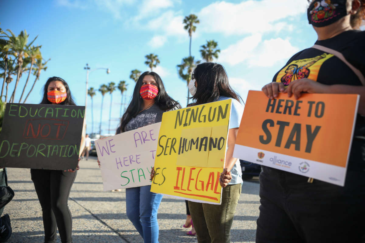 People hold signs during a rally in support of the Supreme Court's ruling in favor of the Deferred Action for Childhood Arrivals program, in San Diego, California, June 18, 2020.