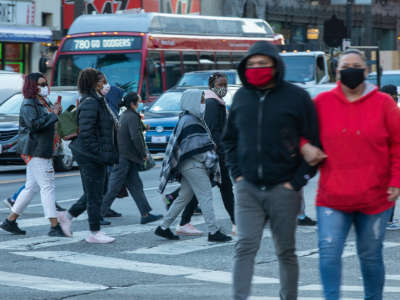 Pedestrians, wearing masks to protect against the coronavirus, cross the street at the intersection of Hollywood Blvd. and Highland Ave. in Hollywood, California, on November 9, 2020.