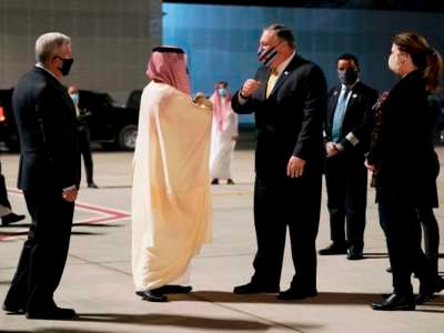 Mike Pompeo greets someone as he exits a plane