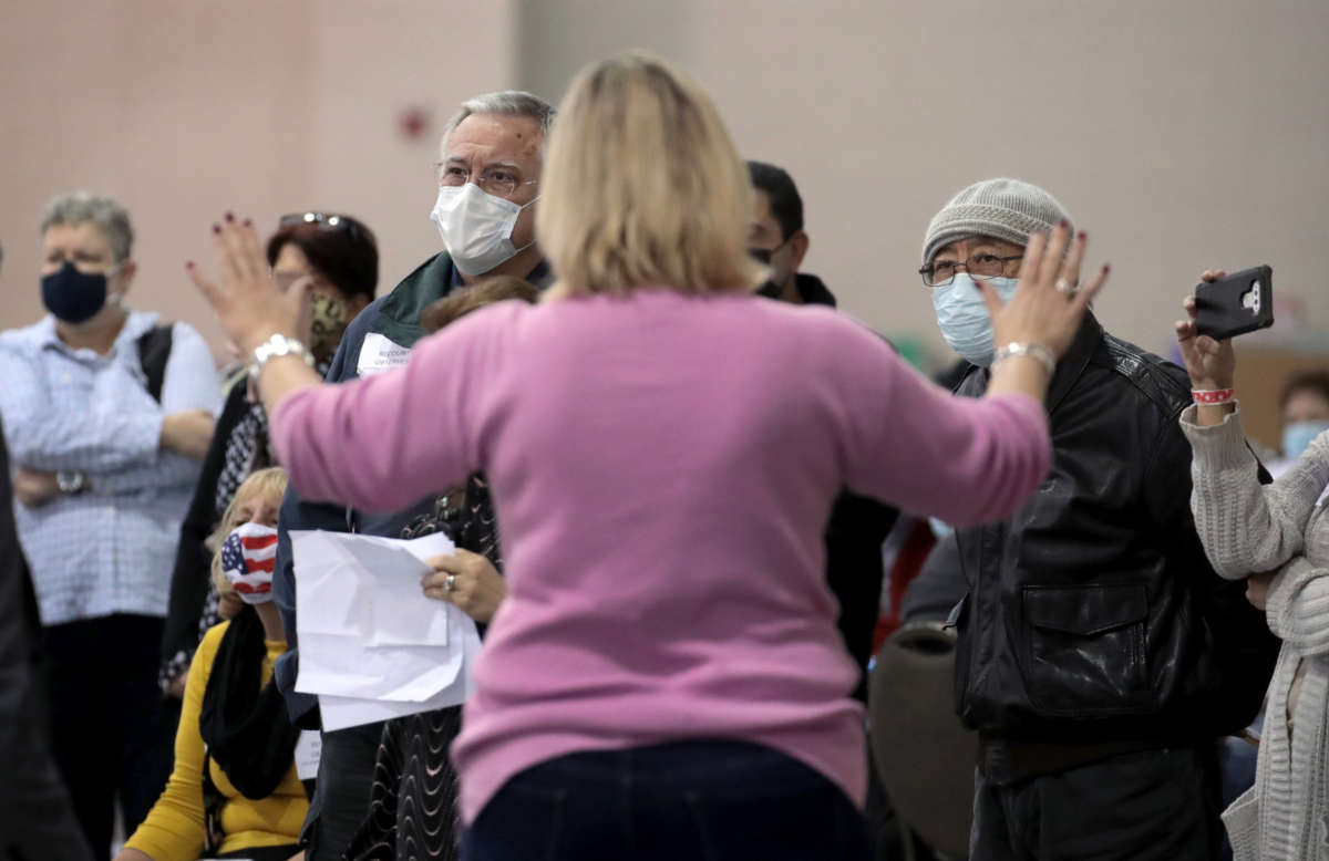 An election official calms unruly observers as procedural issues are argued during the process of recounting ballots from the November 3 election at the Wisconsin Center on November 20, 2020, in Milwaukee, Wisconsin.