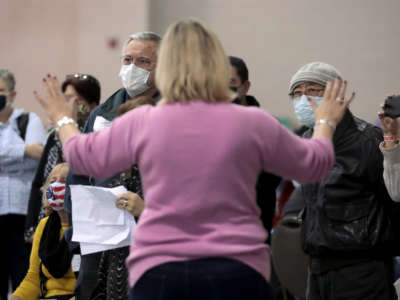 An election official calms unruly observers as procedural issues are argued during the process of recounting ballots from the November 3 election at the Wisconsin Center on November 20, 2020, in Milwaukee, Wisconsin.