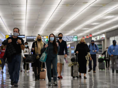 Travelers walk through Washington Dulles International Airport in Dulles, Virginia, on November 24, 2020.