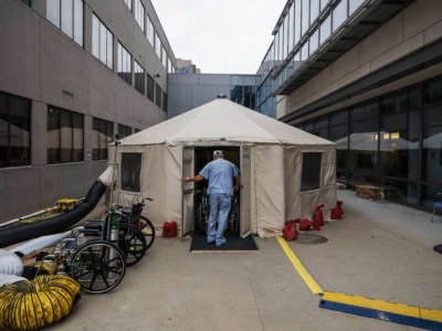 A PCA rolls a patient out of a temporary tent set up at UMass Memorial Hospital in Worcester, Massachussetts, on November 11, 2020.